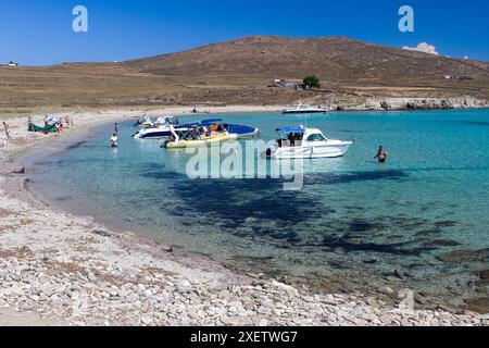 Die malerische Bucht von Rheneia, Griechenland, wo kristallklares türkisfarbenes Wasser auf die goldene Küste trifft, perfekt für einen entspannenden Tag am Meer. Stockfoto