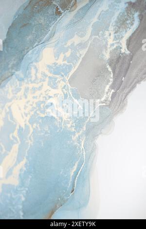 Ein abstraktes Gemälde aus Nahaufnahme mit einer wirbelnden Mischung aus hellblauem und grauem Aquarell. Zarte weiße Adern ziehen sich durch die Farbe und erzeugen einen Stockfoto