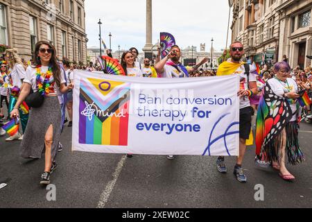 London, Großbritannien. Juni 2024. Mental Health Charity Mind mit einem Fahnenplädoyer für ein Verbot der Konversionstherapie. Teilnehmer und Zuschauer haben Spaß auf der Strecke bei der Pride in London 2024 Parade. Die Parade verläuft vom Hype Park entlang Piccadilly nach Whitehall und eine Party am Trafalgar Square. Sie zelebriert Vielfalt und die LGBT-Community. Quelle: Imageplotter/Alamy Live News Stockfoto