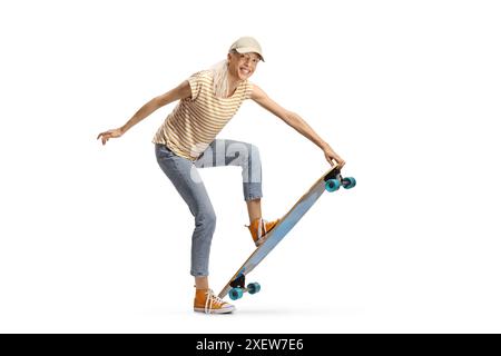 Fröhliche junge Frau mit einem Longboard, das auf weißem Hintergrund in die Kamera lächelt Stockfoto