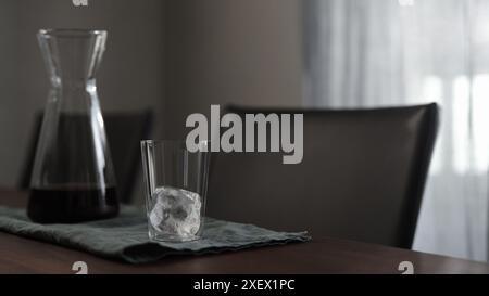 Eiswürfel aus Glas auf Walnusstisch, breites Foto Stockfoto