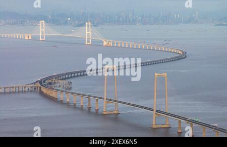 Peking, China. Juni 2024. Eine Luftdrohne, die am 27. Juni 2024 aufgenommen wurde, zeigt die Shenzhen-Zhongshan-Verbindung in der südchinesischen Provinz Guangdong. Die Shenzhen-Zhongshan-Verbindung ist ein zentrales Verkehrsknotenprojekt im Großraum Guangdong-Hongkong-Macao. Es besteht aus einem Unterwassertunnel, zwei Brücken und zwei künstlichen Inseln und ist damit eines der anspruchsvollsten Cross-Sea-Cluster-Projekte der Welt. Quelle: Mao Siqian/Xinhua/Alamy Live News Stockfoto