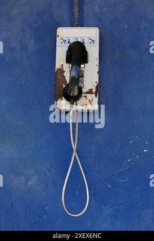 460 funktionierendes altes Münztelefon an der blauen Wand eines Fischerhauses an der einzigen Straße entlang der Insel, Cayo Gramna Key. Santiango-Kuba. Stockfoto