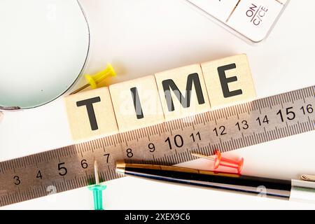 GESCHÄFTSKONZEPT. ZEITBUCHSTABEN auf Holzwürfeln, die entlang des Messlinals angeordnet sind Stockfoto
