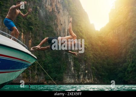 Mann, Boot und Sprung in See für Abenteuer auf der Yacht für Segeln, Urlaub und Sommerurlaub. Stunt, Reise und Tourismus mit Freunden Backflip auf der Reise Stockfoto