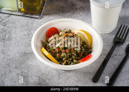 Gesunder Salat mit Quinoa, Kapern und Lachs in schwarzer Schüssel Stockfoto