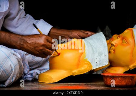 Das Bild aus Kumortuli, Kalkutta, zeigt ein handwerkliches Gemälde des Kopfes der Göttin Durga mit einem Pinsel. Das Bild zeigt den Prozess der Idol-Herstellung. Stockfoto