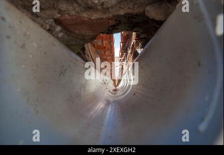 Innenraum einer PVC-Dachrinne am Zusammenfluss eines Giebeldaches. Tunnelsicht Stockfoto