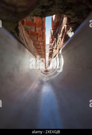 Innenraum einer PVC-Dachrinne am Zusammenfluss eines Giebeldaches. Tunnelsicht Stockfoto