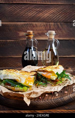 Gegrillte, gefüllte Lavash mit Kräutern, Tomaten und Ei. Lavash-Sandwich Stockfoto
