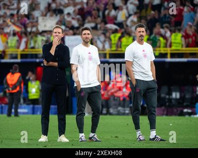 Julian Nagelsmann (Deutschland, Bundestrainer), Benjamin Glueck (Deutschland, Co-Trainer), Sandro Wagner (Deutschland, Co-Trainer) freut sich ueber den Sieg und schauen nachdenklich zur Tribuene mit Fans und Familie, GER gegen Dänemark (DEN), Fussball Europameisterschaft, UEFA EURO 2024, Achtelfinale 29.06.2024 Foto: Eibner-Pressefoto/Michael Memmler Stockfoto