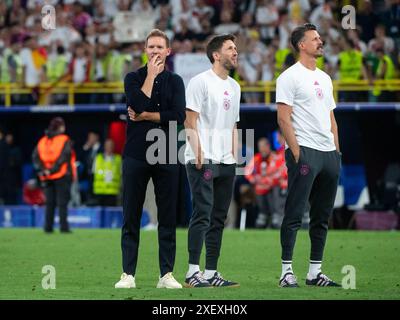 Julian Nagelsmann (Deutschland, Bundestrainer), Benjamin Glueck (Deutschland, Co-Trainer), Sandro Wagner (Deutschland, Co-Trainer) freut sich ueber den Sieg und schauen nachdenklich zur Tribuene mit Fans und Familie, GER gegen Dänemark (DEN), Fussball Europameisterschaft, UEFA EURO 2024, Achtelfinale 29.06.2024 Foto: Eibner-Pressefoto/Michael Memmler Stockfoto