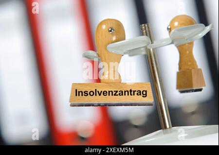 Insolvenzantrag in einem Büro mit Aktenordner hängt ein Holzstempel mit dem Aufdruck: Insolvenzantrag *** Insolvenzantrag in einem Büro mit Aktenordner Stockfoto