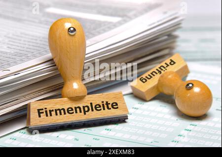 Firmenpleite an einem Papierstapel lehnt ein Holzstempel mit dem Aufdruck: Firmenpleite und Prüfung *** Firmenbankrott Eine Holzmarke mit dem Wor Stockfoto