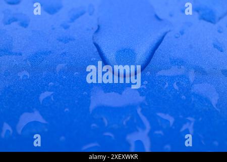 Köln, Deutschland. 30. Juni 2024. Wassertropfen laufen durch den blauen Lack eines Autos. Quelle: Roberto Pfeil/dpa/Alamy Live News Stockfoto