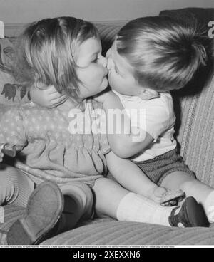 In den 1950er Jahren Ein Junge gibt einem Mädchen einen kleinen Kuss. 1952 Stockfoto