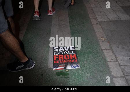 Tel Aviv, Israel. Juni 2024. Ein Poster mit dem Text "Rettet Israel vor Netanjahu" während der Demonstration. Israelische Demonstranten auf einer Demonstration, die zu einem Geiselabkommen und zur Ersetzung der Regierung von Binyamin Nethanyahu aufruft, die wöchentlich in Tel Aviv stattfindet. Während der Kundgebung marschierten die Familien der Geiseln mit der Menge zum "Histadrut", der allgemeinen Arbeiterorganisation in Israel, um einen Großstreik zu führen und neue Wahlen zu fordern. Demonstranten haben Feuer gelegt und den Ayalon Highway blockiert. Quelle: SOPA Images Limited/Alamy Live News Stockfoto