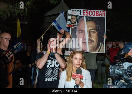 Tel Aviv, Israel. Juni 2024. ADVA Dadon, israelischer TV-Reporter, berichtet von der Demonstration. Israelische Demonstranten auf einer Demonstration, die zu einem Geiselabkommen und zur Ersetzung der Regierung von Binyamin Nethanyahu aufruft, die wöchentlich in Tel Aviv stattfindet. Während der Kundgebung marschierten die Familien der Geiseln mit der Menge zum "Histadrut", der allgemeinen Arbeiterorganisation in Israel, um einen Großstreik zu führen und neue Wahlen zu fordern. Demonstranten haben Feuer gelegt und den Ayalon Highway blockiert. Quelle: SOPA Images Limited/Alamy Live News Stockfoto