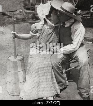 Vintage-Foto der Liebe. Chinnieren, nicht churnen. 1906 Küssen der Bauer und der Milchfrau; Frau mit Butterfass. Stockfoto