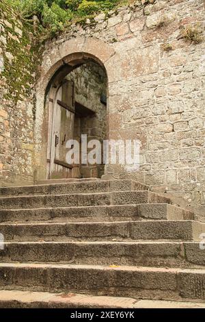 Eine Treppe führt zu einer Eingangstür einer umliegenden Mauer am Mont Saint-Michel in der Normandie. Stockfoto