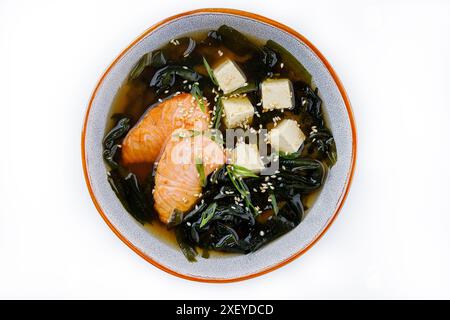 Japanische Miso-Suppe mit Lachs, Tofu und Algen in einer Schüssel auf dunklem Hintergrund. Draufsicht. Stockfoto