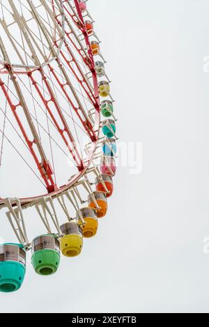 Buntes Riesenrad vor weißem Himmel mit Kopierraum. Stockfoto