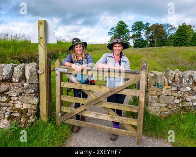 Zwei Damen mit Hexenhüten posieren für ein Foto bei Steel Rigg während ihres Spaziergangs entlang der Hadrian's Wall in Northumberland, England Stockfoto