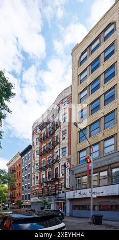 NYC Chinatown: 54 Eldridge Street ist ein siebenstöckiges Apartmenthaus aus rotem Backstein mit weiß gestrichenen Terracotta-Elementen und Geschäften auf Straßenebene. Stockfoto