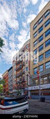 NYC Chinatown: 54 Eldridge Street ist ein siebenstöckiges Apartmenthaus aus rotem Backstein mit weiß gestrichenen Terracotta-Elementen und Geschäften auf Straßenebene. Stockfoto