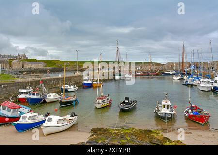 Portsoy Boat Festival farbenfrohe Reihe kleiner Fischerboote im Hafen bei Ebbe Stockfoto