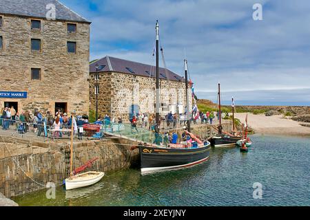 Portsoy Boat Festival kleine Boote mit Fahnen, die im alten Hafen und am kleinen Sandstrand verankert sind Stockfoto