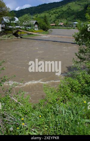 Hängebrücke über den schnell fließenden Fluss in den Karpaten, Rumänien Stockfoto