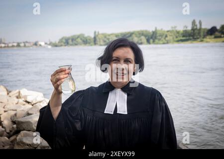 Mehr als 250 Kinder, Jugendliche und Erwachsene sind am Samstag bei einem großen Tauffest in der Bonner Rheinaue getauft worden Foto vom 29.06.2024: Superintendentin Claudia Müller-Buck Müller-Bück schoepft Rheinwasser für das Tauffest. Der Gottesdienst mit 4,000 Besucherinnen und Besuchern wurde auf einer großen Wiese gefeiert, wie der evangelische Kirchenkreis Bonn mitteilte. Die Taufen in kleinen Gruppen uebernahmen 50 Pfarrerinnen und Pfarrer, Vikare, Praedikantinnen und Diakone sowie der rheinischen Praeses. Siehe epd-Berichte vom 29. 30.06.2024 NUR REDAKTIONELLE VERWENDUNG *** mehr als 250 Stockfoto