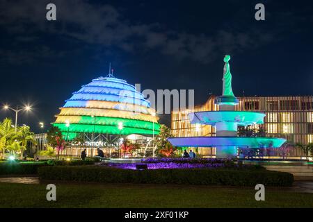 KIGALI, RUANDA - 6. November 23: Das Kigali Convention Centre beleuchtet nachts in verschiedenen Farben. Man kann draußen Leute sehen Stockfoto