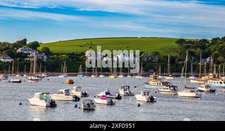 Malerische Aussicht auf Boote in einer Bucht von Falmouth Cornwall mit einer malerischen Küstenstadt und grünen Hügeln im Hintergrund Stockfoto