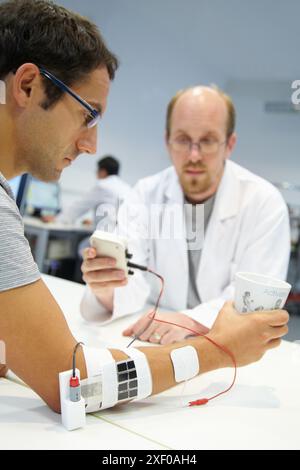 Forscher, die multipad-Elektroden im Kontrollarm für das Stimulationsmodell für Sensorsignale einsetzen Anwendungen zur Rehabilitation der unteren Extremität Stockfoto