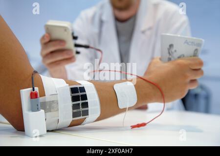 Forscher, die multipad-Elektroden im Kontrollarm für das Stimulationsmodell für Sensorsignale einsetzen Anwendungen zur Rehabilitation der unteren Extremität Stockfoto
