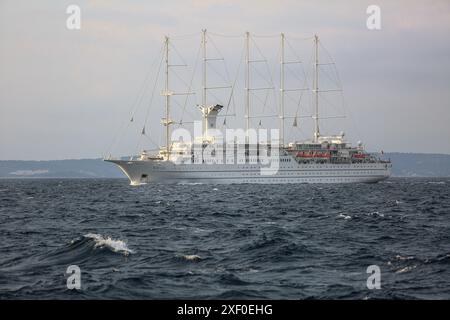 Korčula, Kroatien. 30. Juni 2024: Bei Tagesanbruch segelt das fünf-Masten-Kreuzfahrtschiff WINDSURF, eines der größten Segelschiffe der Welt, in der Adria und nähert sich der Insel Mljet. Das Schwesterschiff des French CLUB MED 2, früher als CLUB MED 1 bekannt, erreicht die Stadt Korcula nahe Dubrovnik an der dalmatinischen Küste. Windstar Cruises, der riesige Besitzer von Staysail-Schonern, hat eine mehrjährige Initiative gestartet, um seine Yachten der Wind-Klasse neu zu gestalten und zu renovieren: Wind Star, Wind Spirit & Wind Surf (Flaggschiff der Flotte), die Arbeiten an letzteren in zwei Phasen Ende 2024 und 2026. Quelle: Kevin Izorce/Alamy Live News Stockfoto