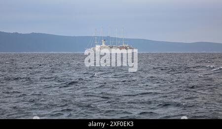 Korčula, Kroatien. 30. Juni 2024: Bei Tagesanbruch segelt das fünf-Masten-Kreuzfahrtschiff WINDSURF, eines der größten Segelschiffe der Welt, in der Adria und nähert sich der Insel Mljet. Das Schwesterschiff des French CLUB MED 2, früher als CLUB MED 1 bekannt, erreicht die Stadt Korcula nahe Dubrovnik an der dalmatinischen Küste. Windstar Cruises, der riesige Besitzer von Staysail-Schonern, hat eine mehrjährige Initiative gestartet, um seine Yachten der Wind-Klasse neu zu gestalten und zu renovieren: Wind Star, Wind Spirit & Wind Surf (Flaggschiff der Flotte), die Arbeiten an letzteren in zwei Phasen Ende 2024 und 2026. Quelle: Kevin Izorce/Alamy Live News Stockfoto