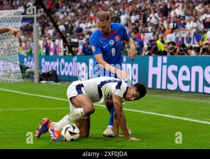 Der Engländer Jude Bellingham (links) und der slowakische Ondrej Duda kämpfen um den Ball während der UEFA Euro 2024, im Achtelfinale in der Arena AufSchalke in Gelsenkirchen. Bilddatum: Sonntag, 30. Juni 2024. Stockfoto