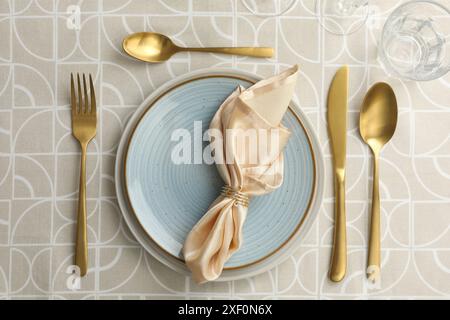 Stilvolle Einrichtung mit Besteck, Tellern, Serviette und Glas auf dem Tisch, flach gelegen Stockfoto