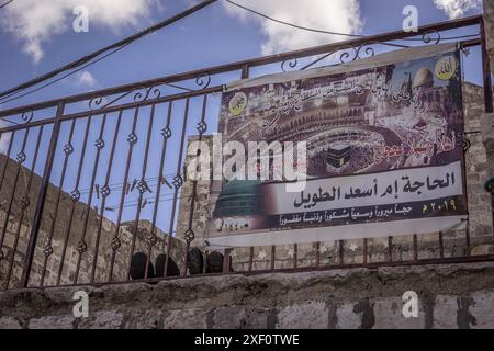Auf dem Banner mit der Werbung von Hadj (Hajj) steht in Arabisch: „Hajj, eine belohnte Anstrengung und eine vergebliche Sünde“ auf dem Haus in Jerusalem. Stockfoto