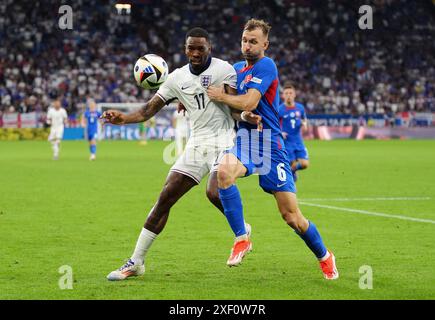 Der Engländer Ivan Toney (links) und der slowakische Norbert Gyomber kämpfen um den Ball während der UEFA Euro 2024, im Achtelfinale in der Arena AufSchalke in Gelsenkirchen. Bilddatum: Sonntag, 30. Juni 2024. Stockfoto