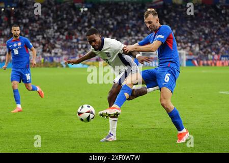 Der Engländer Ivan Toney (links) und der slowakische Norbert Gyomber kämpfen um den Ball während der UEFA Euro 2024, im Achtelfinale in der Arena AufSchalke in Gelsenkirchen. Bilddatum: Sonntag, 30. Juni 2024. Stockfoto