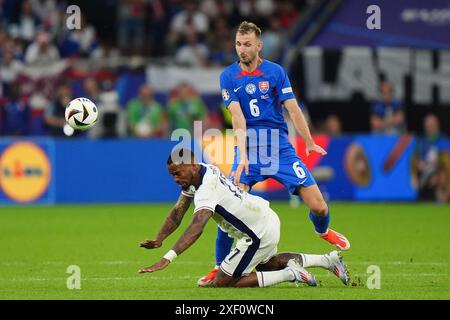 Der Engländer Ivan Toney (links) und der slowakische Norbert Gyomber kämpfen um den Ball während der UEFA Euro 2024, im Achtelfinale in der Arena AufSchalke in Gelsenkirchen. Bilddatum: Sonntag, 30. Juni 2024. Stockfoto