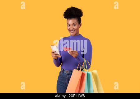Glückliche Frau mit Smartphone und Kreditkarte für Online-Shopping Stockfoto