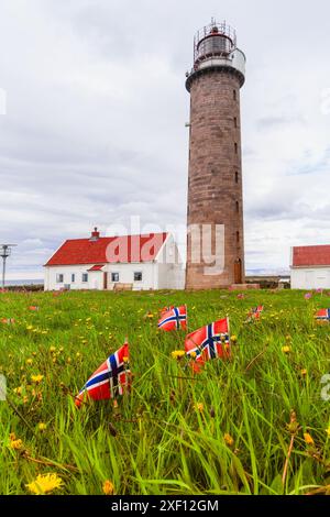 Lista Lighthouse, an der Südwestküste Norwegens gelegen, umgeben von einem Feld, das mit kleinen norwegischen Flaggen geschmückt ist. Gut, Südnorwegen zu fördern Stockfoto
