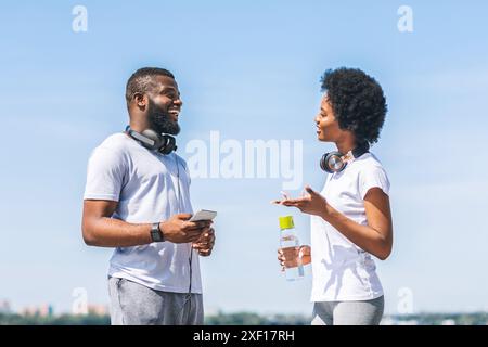 Paar sprechen über Laufen Training Plan in der Nähe des Flusses Stockfoto