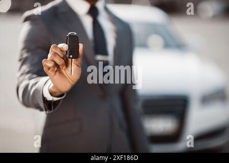 Mann, der den Autoschlüssel vor dem Neuwagen hält, abgeschnitten Stockfoto