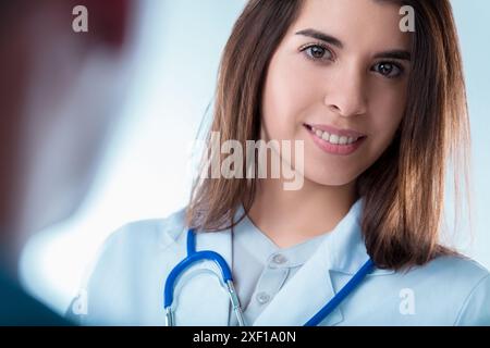 Die junge Ärztin hört ihren Patienten während einer medizinischen Beratung aufmerksam zu und zeigt Empathie und Professionalität Stockfoto